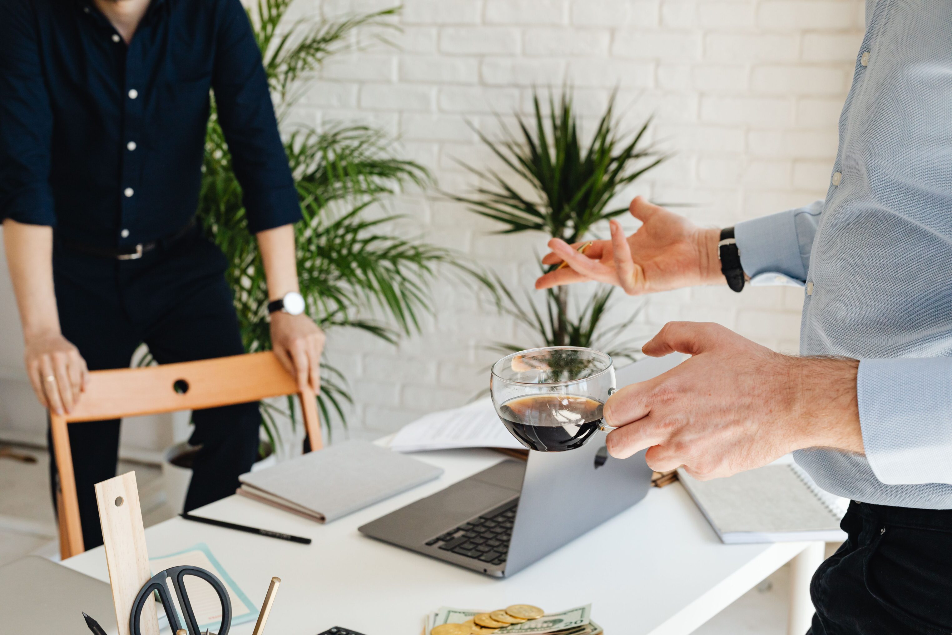 Two people at an office talking over coffee