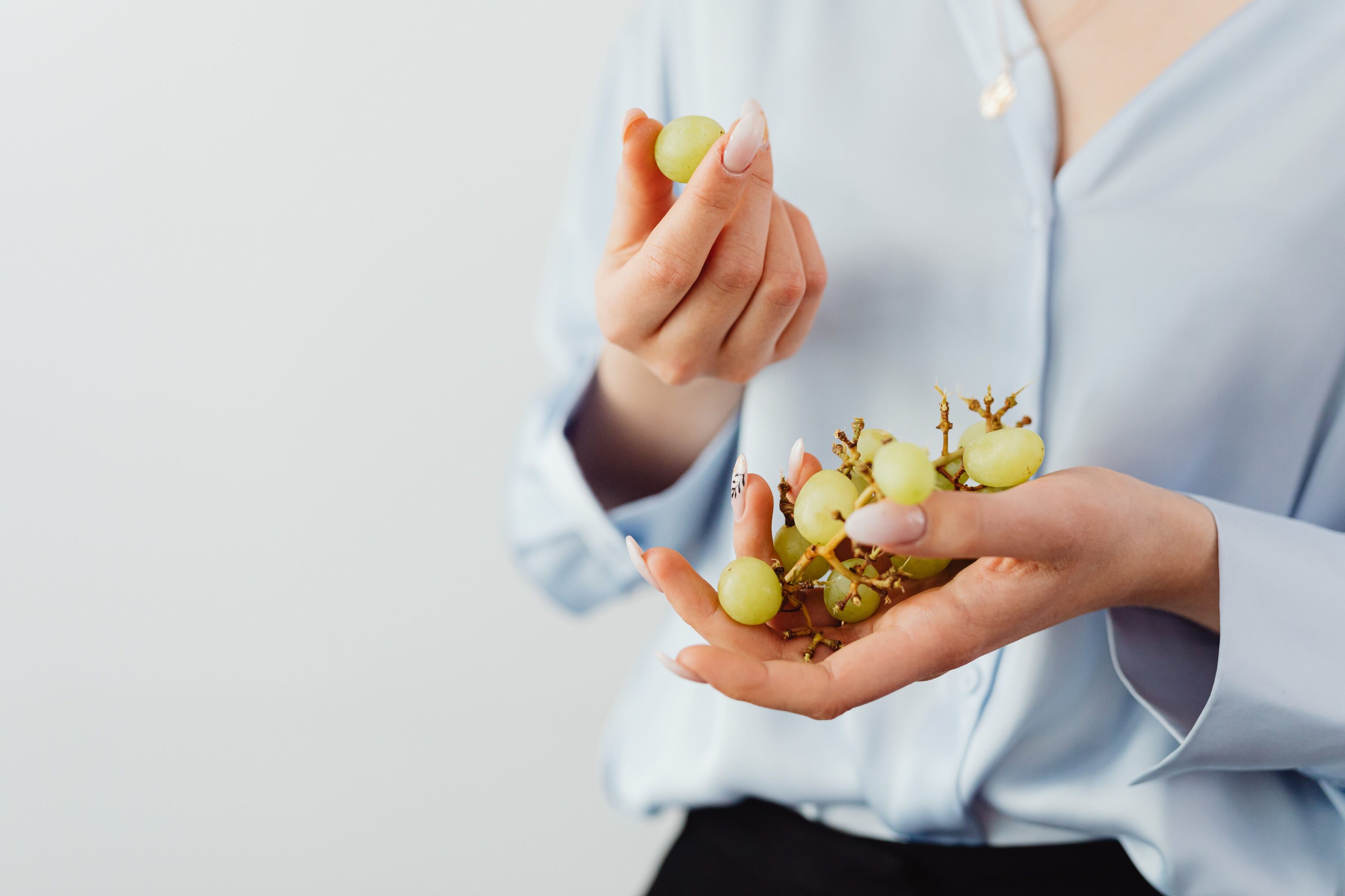 Office worker holding grapes