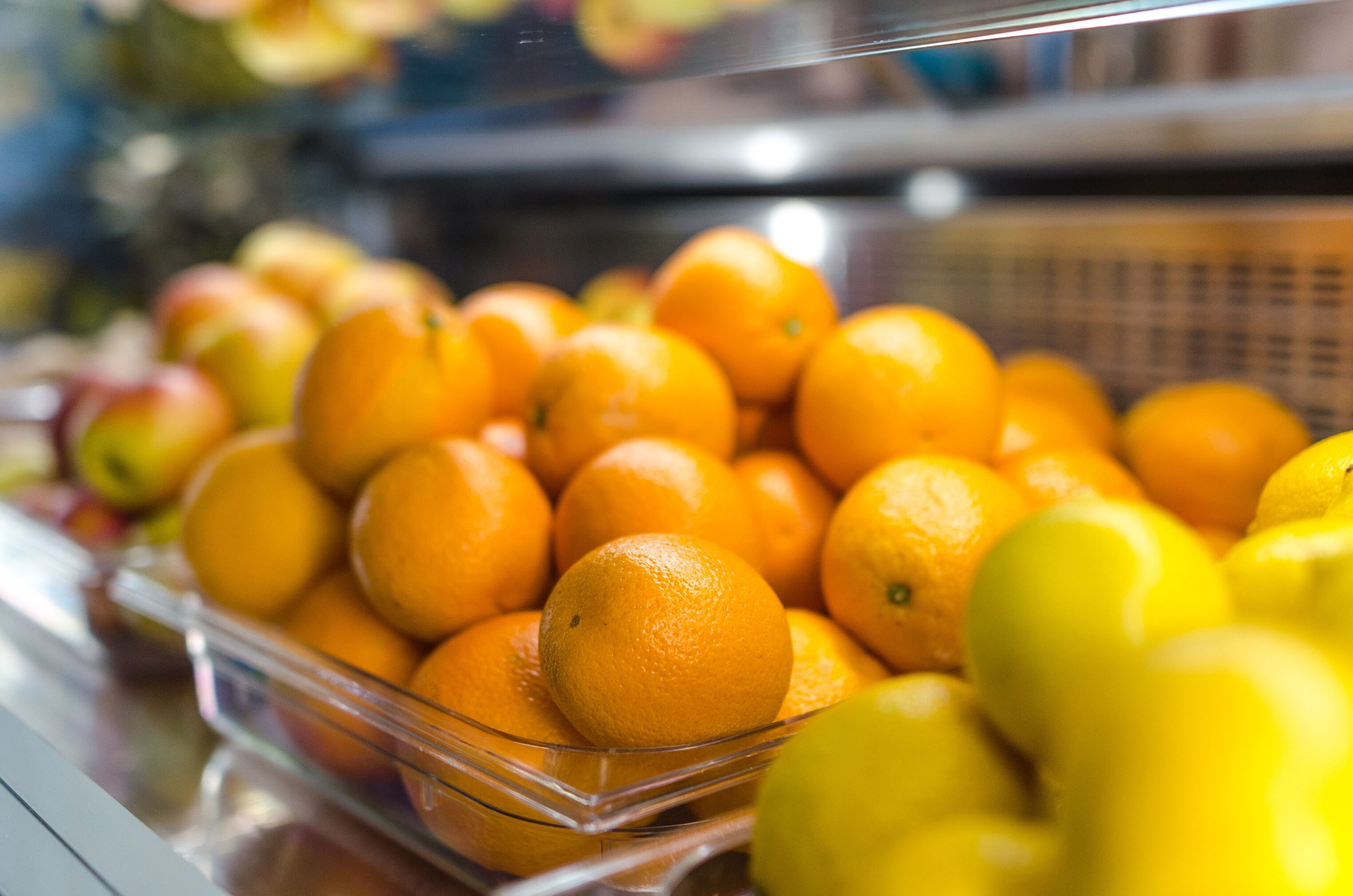 Well lit selection of office fruit, including oranges, apples etc